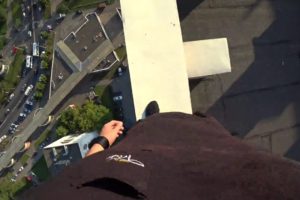 Parkour Runner Misses Jump And Falls Off High Rise Roof, Catches Himself On Electric Wires