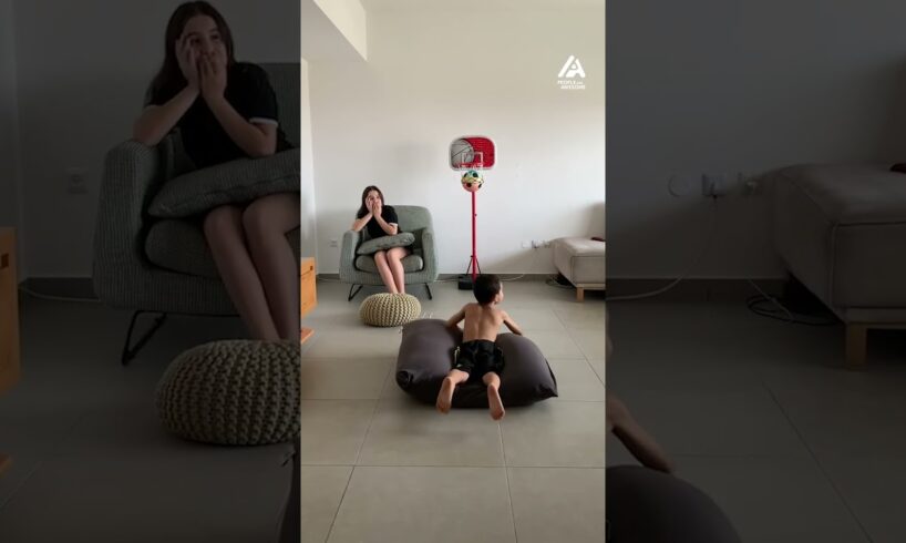 Boy Chilling Indoors Casually Flicks Ball into Basket Without Looking